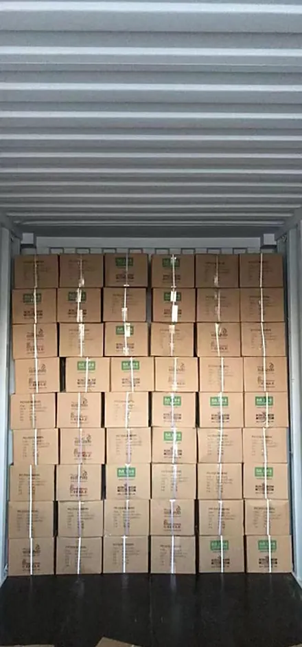 Container interior filled with stacked cartons of edge banding
